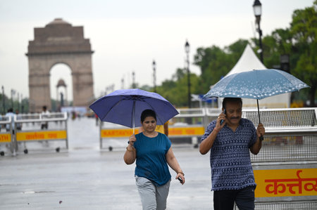 NEW DELHI INDIA JUNE 25 2023 Visitors and morning walkers enjoying in the light rain at near India Gate on June 25 2023 in New Delhi India Heavy rainfall accompanied by lightning lashed several parts of the national capital Delhi and its adjoining areas iのeditorial素材