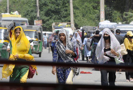 GURUGRAM INDIA APRIL 13 2023 Commuters seen covering their head with a cloth to escape from sun s heat as seen at old Delhi road near Bus stand on April 13 2023 in Gurugram India Photo by Parveen Kumar Hindustan Timesのeditorial素材