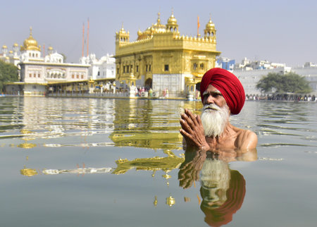AMRITSAR INDIA APRIL 14 2023 A devotee takes a bath in the holy sarovar water tank on the occasion of Baisakhi at Golden Temple on April 14 2023 in Amritsar India Baisakhi also known as Vaisakhi is an important and popular harvest festival celebrated in tのeditorial素材