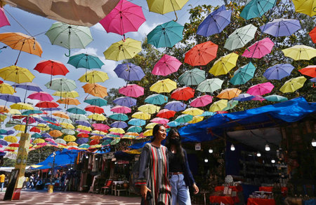 NEW DELHI INDIA APRIL 18 2023 Visitors walks under the Umbrella Roof at Dilli Haat which give some...