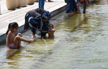NEW DELHI INDIA APRIL 14 2023 Devotees take a dip in the sacred pond of Gurudwara Bangla Sahib on the occasion of Vaisakhi festival on April 14 2023 in New Delhi India Baisakhi also known as Vaisakhi is an important and popular harvest festival celebratedのeditorial素材