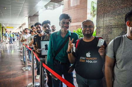 NEW DELHI INDIA APRIL 20 2023 Customers wait in line outside the new Apple Inc store ahead of its...