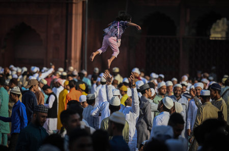 NEW DELHI INDIA APRIL 22 2023 A person plays with his daughter after offering Eid al Fitr prayer marking the end of the holy fasting month of Ramadan at the Jama Masjid on April 22 2023 in New Delhi India Muslims around the world are getting into the festのeditorial素材
