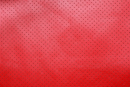 Red perforated leather texture backgroundの写真素材