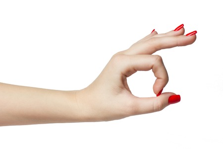 Woman hand in ok sign with manicure and red nails on a white isolatedの写真素材