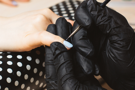 Woman hand made blue manicure step by stepの写真素材