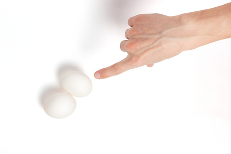 hand is pointing on eggs a white backgroundの写真素材