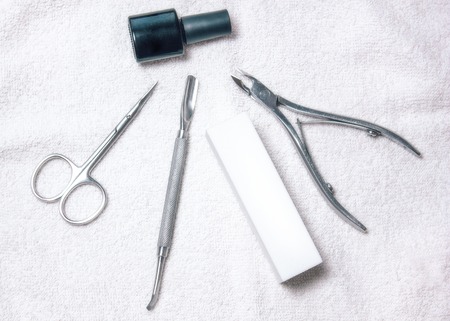 beautifully manicured nails on the desktop with tools for manicureの写真素材