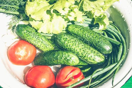 A set of fresh vegetables on the white background close-up. Pile of Vegetables in water - vegetable marrow, onions, cucumber, tomato, salad, dillの写真素材