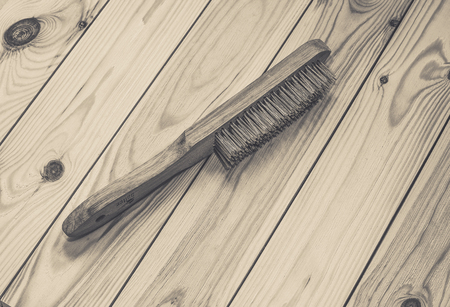 Wire brush with wooden handle on raw wooden background.の写真素材