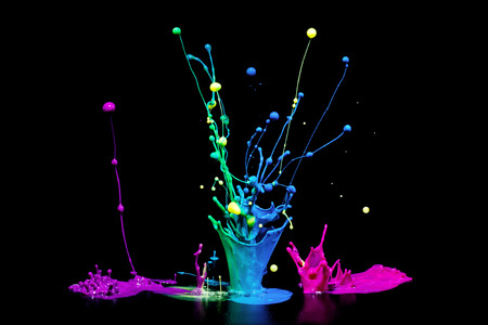This is a colorful paint splash on a audio speaker isolated on a black background. の写真素材