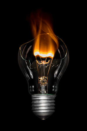 Broken light  bulb with flame.の写真素材