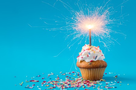 Birthday Cupcake with a sparkler on blue backgroundの写真素材