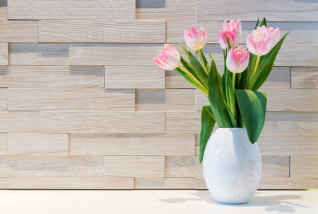 Beautiful bouquet of fresh tulips flowers against brick wall backgroundの写真素材
