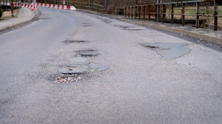 Infrastructure degradation. Poor condition of the road surface. Hole in the asphaltの写真素材