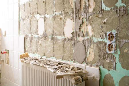 Bathroom renovation - removing tiles in old apartment bathroom from drywallの写真素材