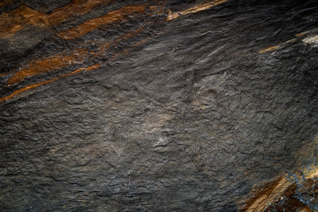 Texture of a natural rock surface in close-up, showingcasing patterns and earthy tones, ideal for backgrounds or geological studies.の写真素材