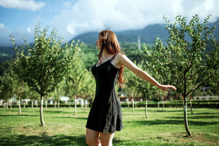A girl in light summer clothes walks through the mountainous area near the riverの写真素材