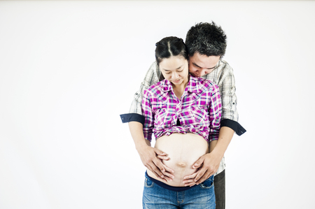 Image of pregnant couple. Husband touching his wife belly with handsの写真素材