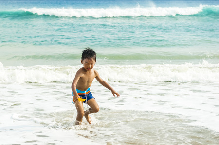 Little baby boy sitting on the sandの写真素材