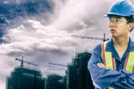 construction worker checking location site with crane on the background