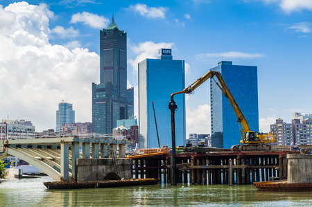 KAOHSIUNG, TAIWAN -- JUNE 14, 2016: An excavator drives a pile into the river bed as construction of a new bridge across the Love River continues.のeditorial素材