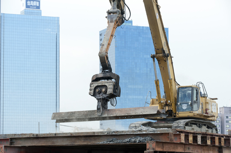 KAOHSIUNG, TAIWAN -- JUNE 14, 2016: An excavator drives a pile into the river bed as construction of a new bridge across the Love River continues.のeditorial素材