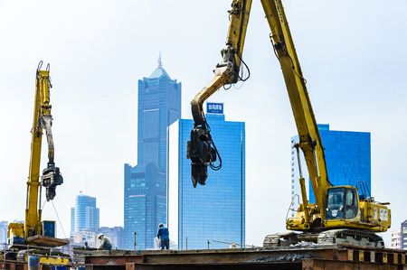 KAOHSIUNG, TAIWAN -- JUNE 14, 2016: An excavator drives a pile into the river bed as construction of a new bridge across the Love River continues.のeditorial素材