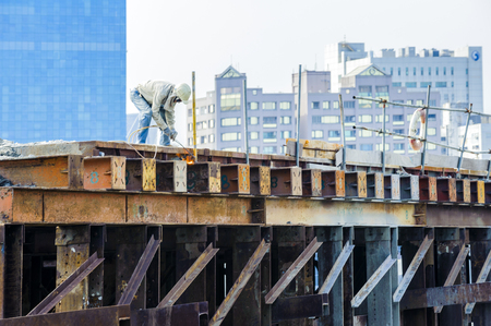 KAOHSIUNG, TAIWAN -- JUNE 14, 2016: An excavator drives a pile into the river bed as construction of a new bridge across the Love River continues.のeditorial素材