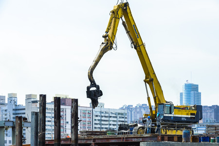 KAOHSIUNG, TAIWAN -- JUNE 14, 2016: An excavator drives a pile into the river bed as construction of a new bridge across the Love River continues.のeditorial素材