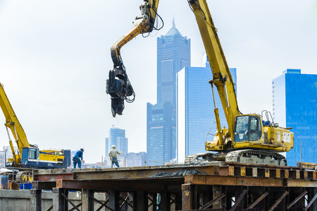 KAOHSIUNG, TAIWAN -- JUNE 14, 2016: An excavator drives a pile into the river bed as construction of a new bridge across the Love River continues.のeditorial素材