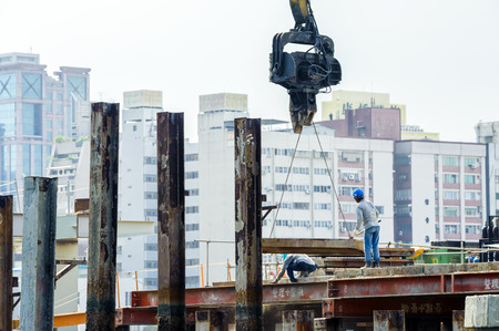 KAOHSIUNG, TAIWAN -- JUNE 14, 2016: An excavator drives a pile into the river bed as construction of a new bridge across the Love River continues.のeditorial素材
