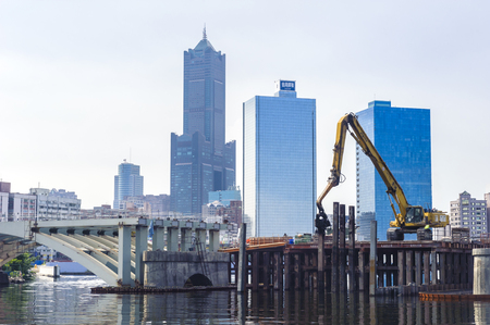 KAOHSIUNG, TAIWAN -- JUNE 14, 2016: An excavator drives a pile into the river bed as construction of a new bridge across the Love River continues.のeditorial素材