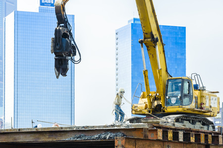 KAOHSIUNG, TAIWAN -- JUNE 14, 2016: An excavator drives a pile into the river bed as construction of a new bridge across the Love River continues.のeditorial素材