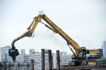 KAOHSIUNG, TAIWAN -- JUNE 14, 2016: An excavator drives a pile into the river bed as construction of a new bridge across the Love River continues.のeditorial素材