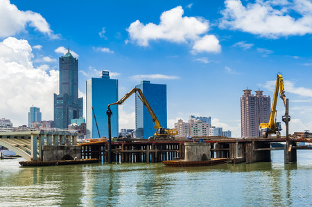 KAOHSIUNG, TAIWAN -- JUNE 14, 2016: An excavator drives a pile into the river bed as construction of a new bridge across the Love River continues.のeditorial素材