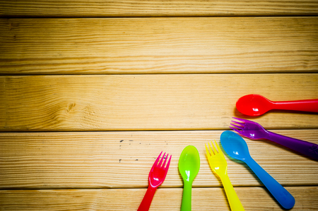 Kids funny eating. Composition of Colorful cutlery on wooden tableの写真素材