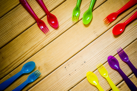 Kids funny eating. Composition of Colorful cutlery on wooden tableの写真素材