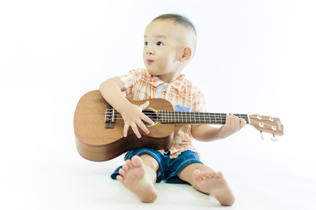Cute little boy with ukulele guitarの写真素材