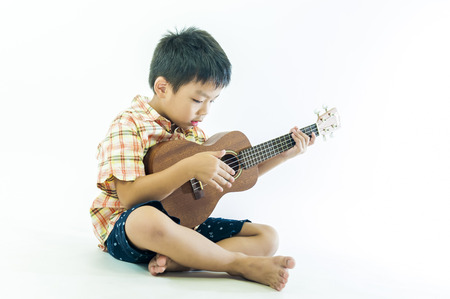 Cute little boy with ukulele guitarの写真素材