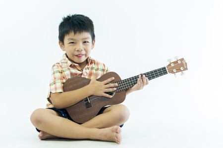 Cute little boy with ukulele guitarの写真素材