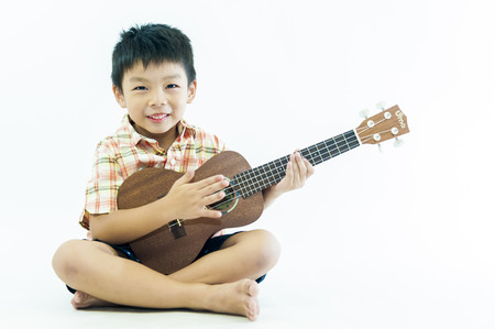 Cute little boy with ukulele guitarの写真素材