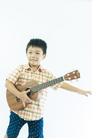 Cute little boy with ukulele guitarの写真素材