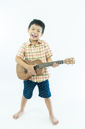 Cute little boy with ukulele guitarの写真素材
