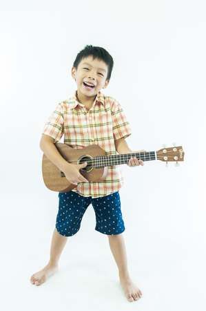 Cute little boy with ukulele guitarの写真素材