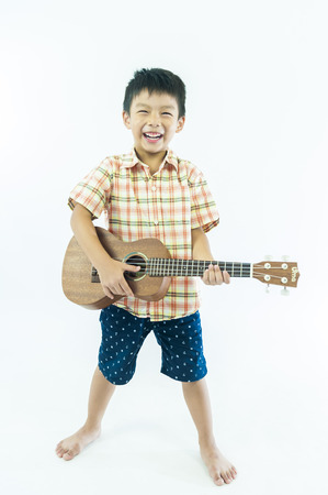 Cute little boy with ukulele guitarの写真素材