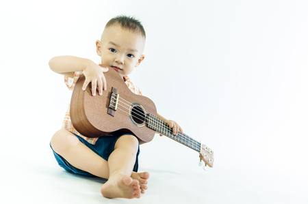 Cute little boy with ukulele guitarの写真素材