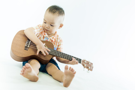 Cute little boy with ukulele guitarの写真素材