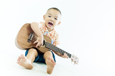 Cute little boy with ukulele guitarの写真素材