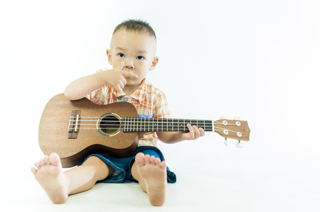 Cute little boy with ukulele guitarの写真素材